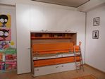 2921 - Cameretta a ponte con ante battenti laccate bianco, struttura in melaminico olmo e dettagli arancio.
Letto inferiore scorrevole con cassettoni, letto superiore scorrevole con cassetti e sistema integrato nel letto, di due piani, che all'occorrenza possono essere estratti ed utilizzati come semplice piano d'appoggio o come una vera e propria scrivania. Team ponte