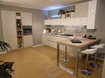 2828 - La cucina con gola Alevè in prezzo affare, è realizzata in laminato materico Calce, laccato lucido UV Neve, piano di lavoro in Okite e piano penisola in Olmo Bianco.
Una composizione dinamica e funzionale. I pensili di diverse dimensioni e finiture, sono posizionati a diverse altezze creando movimento e un forte potere decorativo. I vani a giorno posizionati tra la colonna frigorifero e la colonna forno creano leggerezza.
Inoltre la penisola in forte spessore è protagonista grazie al suo forte impatto estetico. Alevè di Stosa