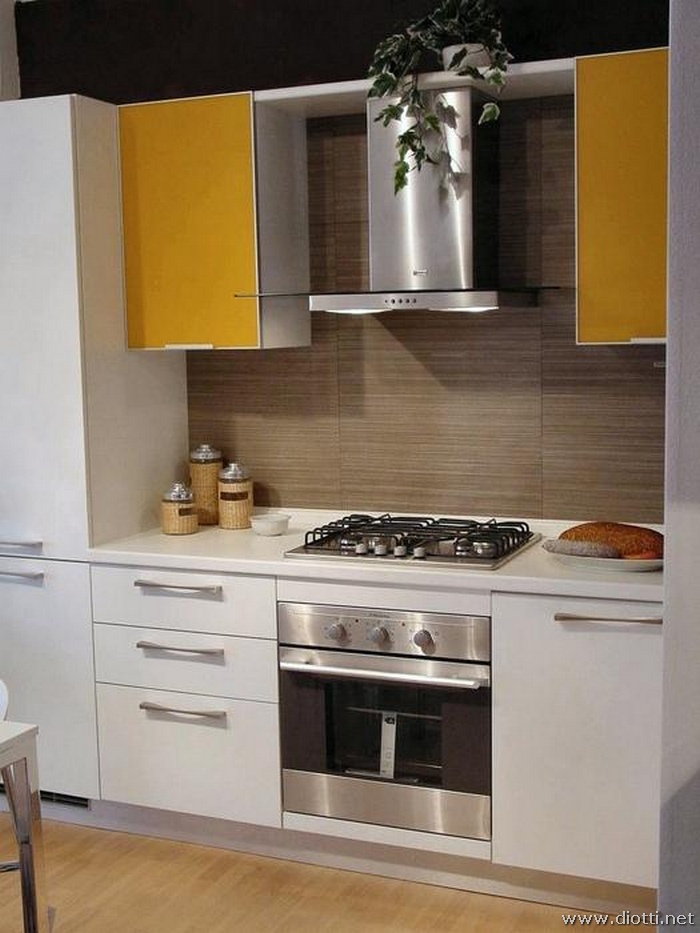 Particolare della cassettiera da 60 con cassetti e cestone, la cappa con i 2 pensili laterali con anta in alluminio e cristallo millerighe giallo.