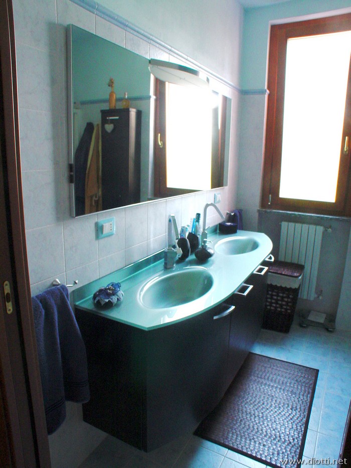 Stupendo il bagno sospeso linea Top con basamento in rovere tinto weng e piano in cristallo azzurro-argento con vasche in fusione.